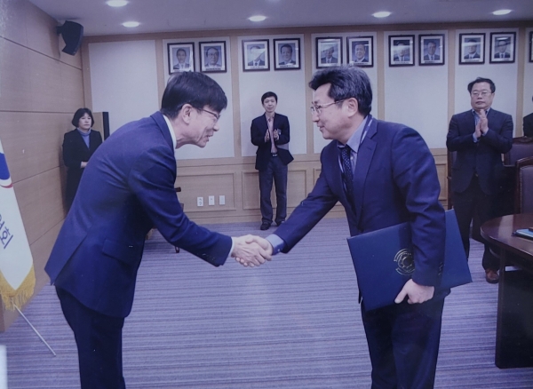김상조 공정거래위원장(왼쪽)이 2018년 고병희 초대 유통정책관에게 임명장을 수여한 후 악수를 하고 있다.
